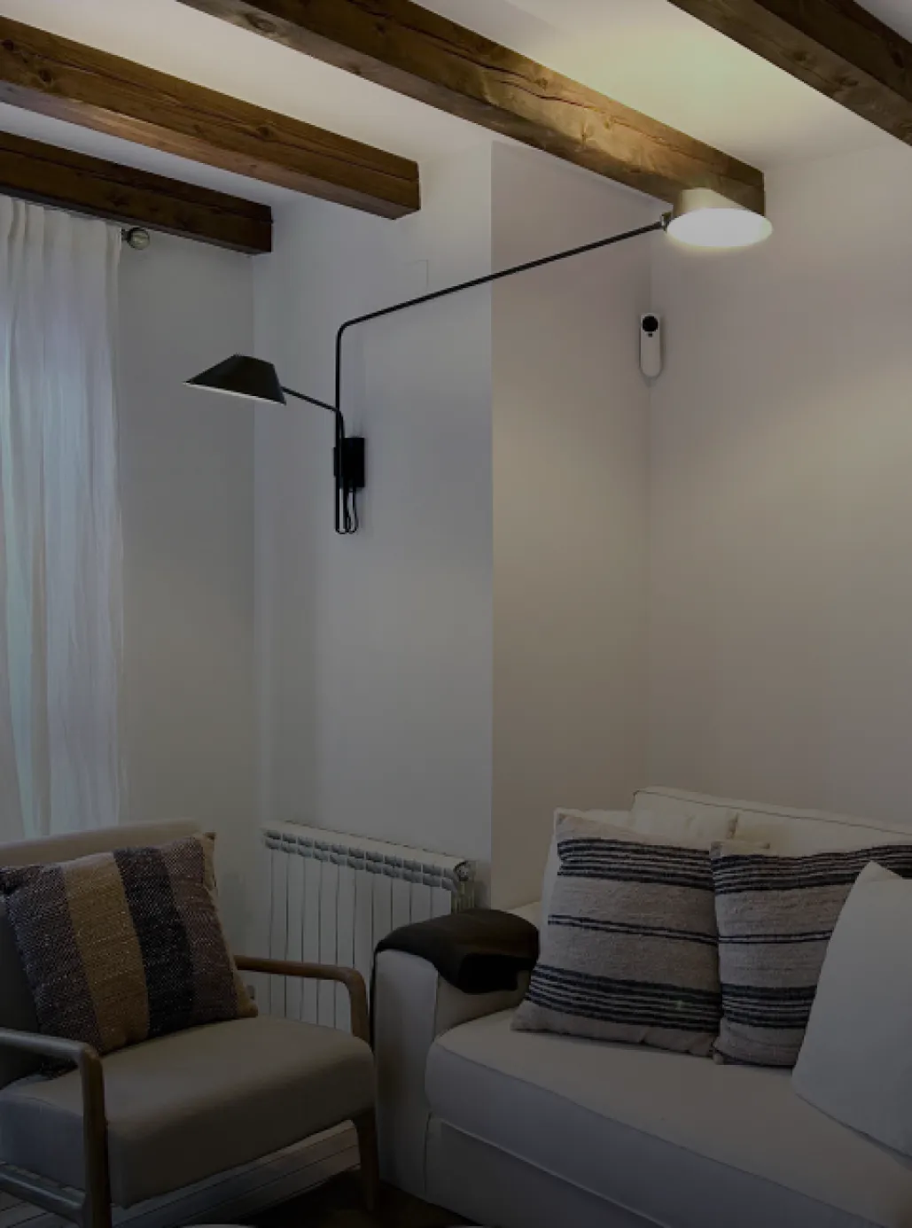Living room with wooden beams, an armchair and striped cushions